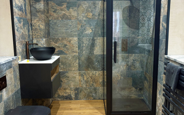 A modern bathroom layout showcasing a shower, toilet, and basin