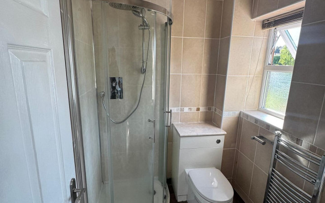 Bathroom featuring a toilet, shower, and basin
