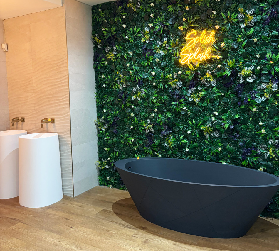 A modern bathroom featuring a green wall and a sleek black bathtub