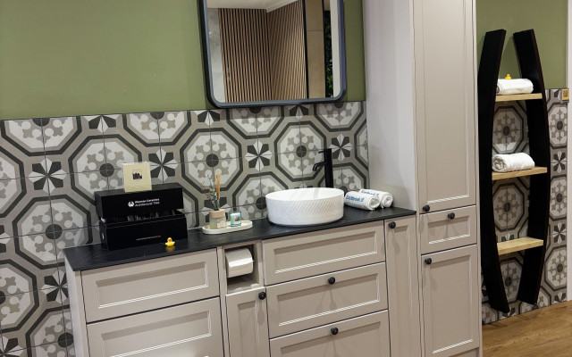 A clean bathroom with a white toilet, basin, and wooden cabinet