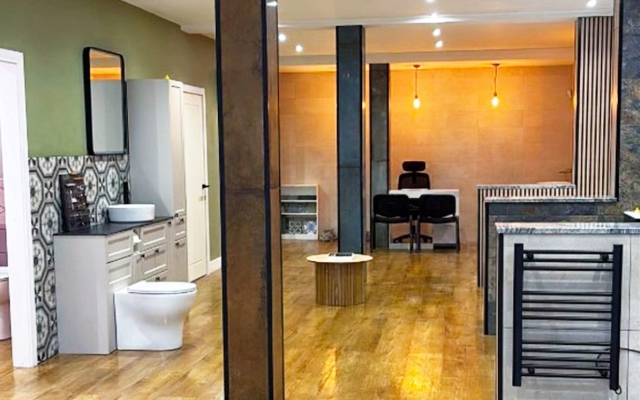 Bathroom showroom with wooden flooring, displaying a basin, toilet and countertop.
