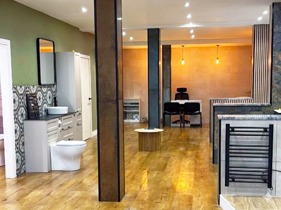 Bathroom showroom with wooden flooring, displaying a basin, toilet and countertop.