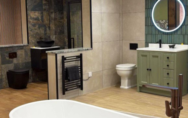 A spacious bathroom showroom featuring a large bathtub and a modern basin